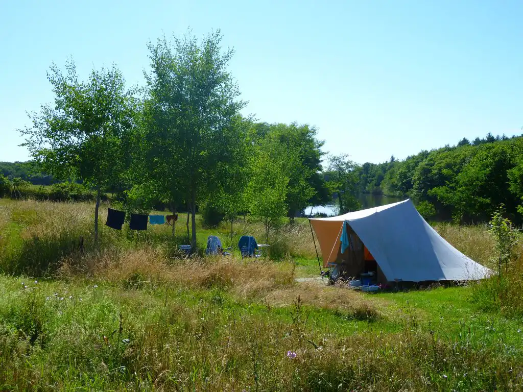 tent op een lege camping met ernaast een lijn met was tussen twee bomen